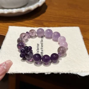 Amethyst-Lilac Dusk bracelet — amethyst and kunzite beads graduating from pale lilac to deep violet, on a white card