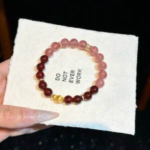 Garnet-Burgundy Muse bracelet — strawberry quartz graduating into deep garnet, with a gold gourd, on a white card